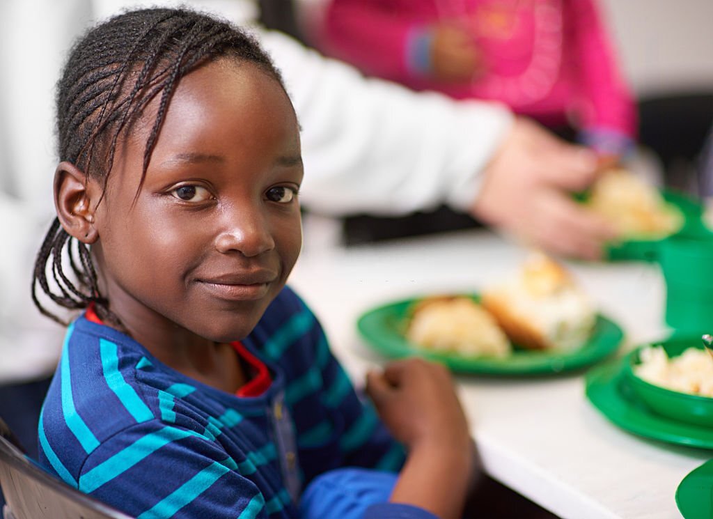 Portrait of a little girl sitting at a dining table with food provided by volunteershttp://195.154.178.81/DATA/i_collage/pi/shoots/805749.jpg